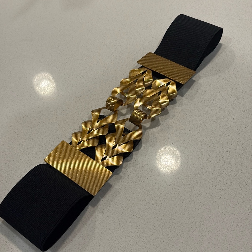 Zara black elastic belt featuring a braided golden metal appliqué.